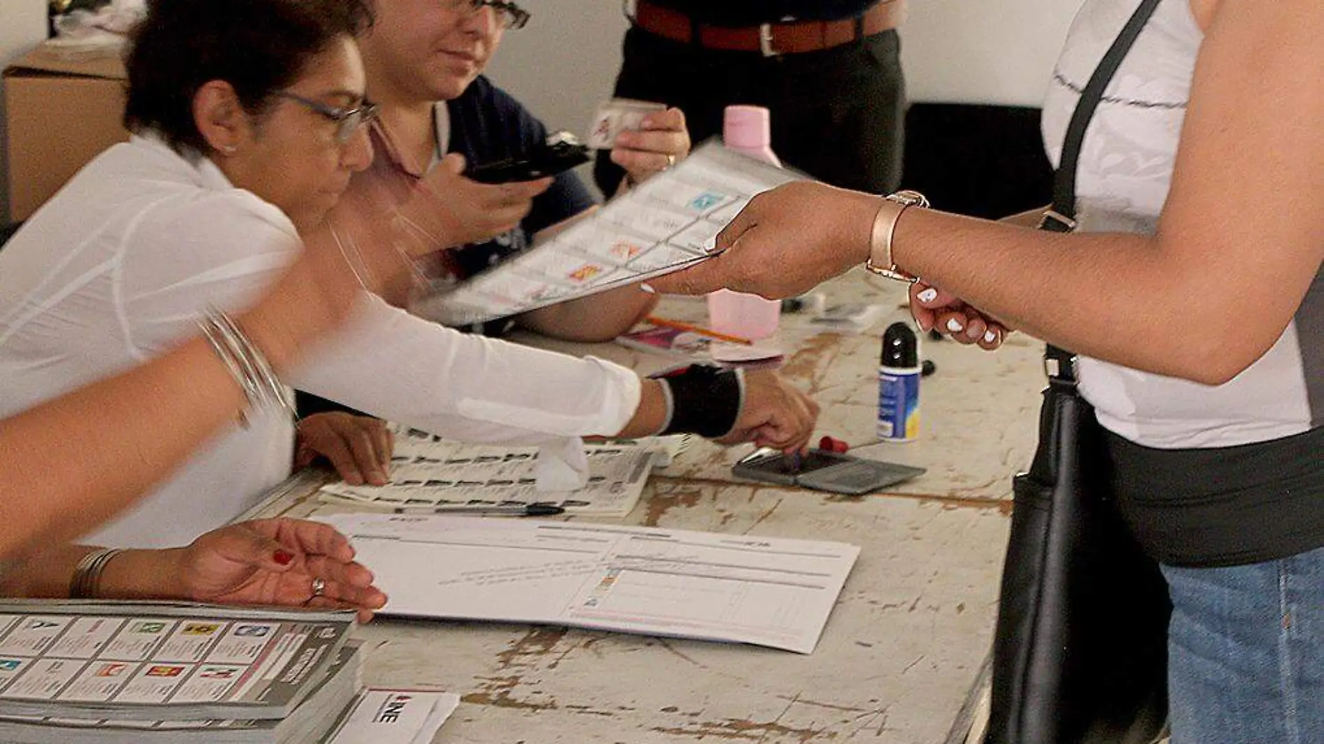 Persona entregando boleta electoral